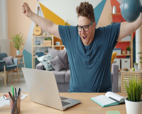 Someone stretching their arms while sitting at a desk doing telework
